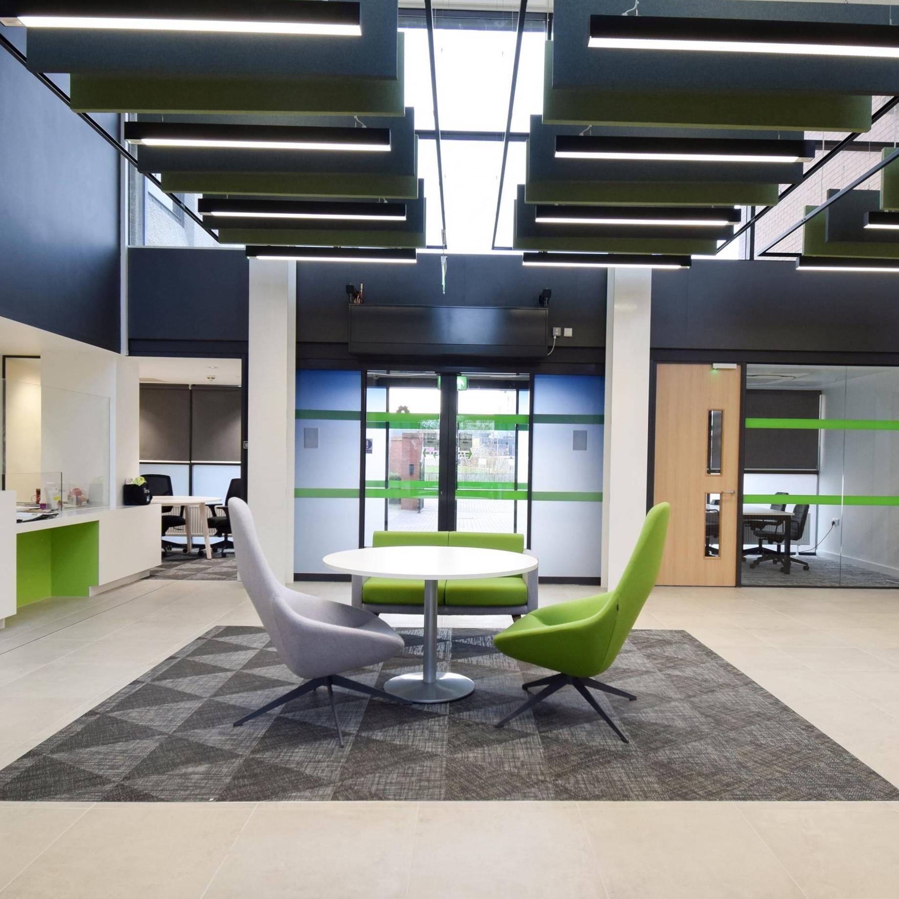 Front of an office with sliding doors plus green and white seating area